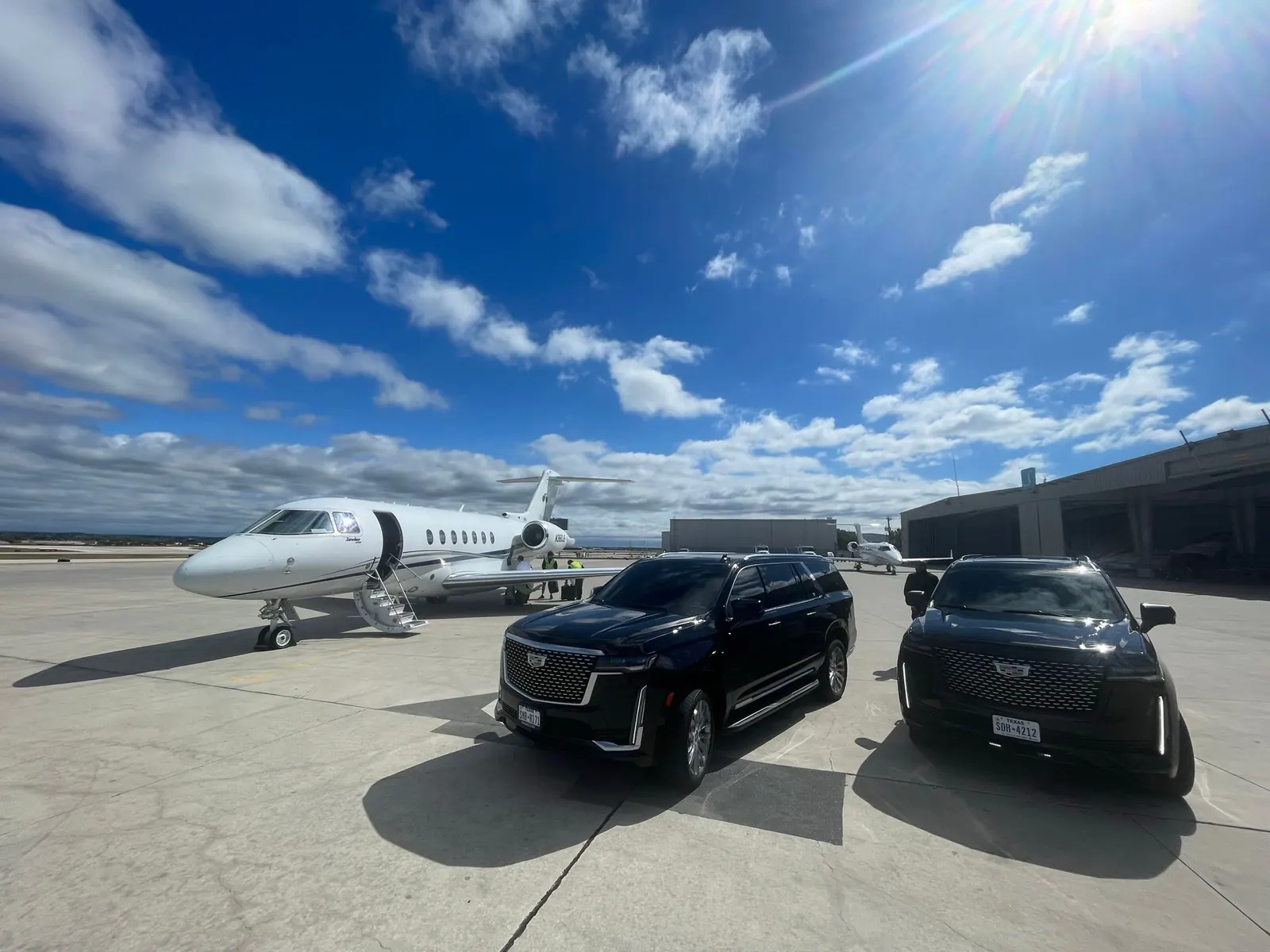 Escalade beside a private jet