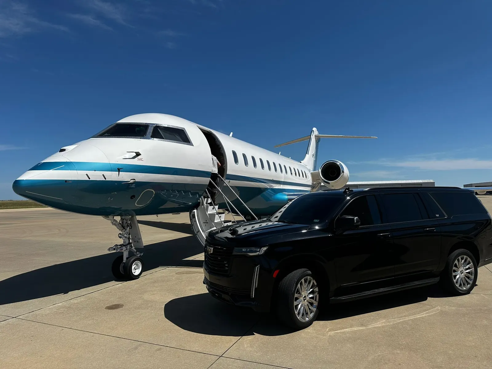 Executive SUV beside a private jet