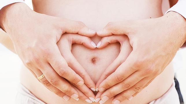 Tạo tr&aacute;i tim bằng đ&ocirc;i tay tr&ecirc;n bụng bầu